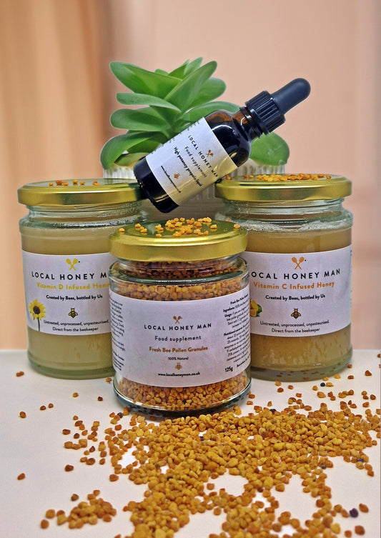 Four jars of local honey raw honey products and bee pollen granules on display, perfect for hay fever relief and natural health.